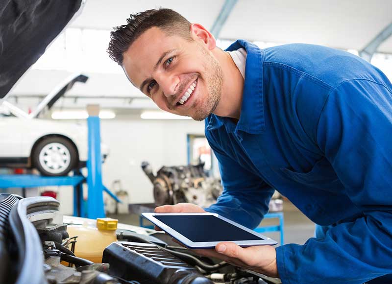 Smiling service tech working on a car